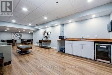 Toronto (Crescent Town) condo for rent - A spacious kitchen and dining area with wooden flooring and modern appliances.