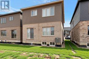 Brantford apartment for rent - A realtor photo of a house with a brown facade and a green lawn.