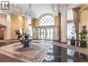 Toronto (Willowdale West) condo for rent - A large, elegant foyer with a chandelier, a large rug, and a glass door.
