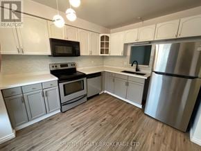 London South (South P) townhouse for rent - A kitchen with white cabinets and a wooden floor.