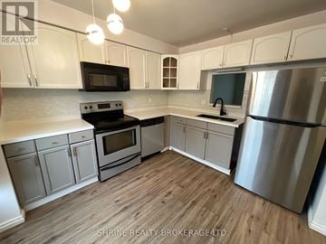 London South (South P) townhouse for rent - A kitchen with white cabinets and a wooden floor.