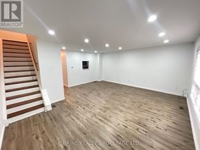 London South (South P) townhouse for rent - A room with wooden flooring and a staircase on the left side.