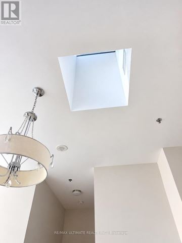 Toronto (South Riverdale) condo for rent - A chandelier hangs from the ceiling in a room with a skylight.
