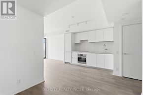 Toronto (Thorncliffe Park) condo for rent - A white kitchen with a refrigerator, oven, and cabinets.
