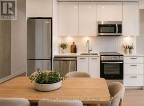 Toronto (Moss Park) condo for rent - A modern kitchen with white cabinets and stainless steel appliances.