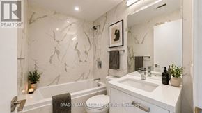 Toronto (Moss Park) condo for rent - A bathroom with a marble wall and a white sink.