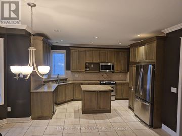 Oakville (Br Bronte) apartment for rent - A modern kitchen with wooden cabinets and stainless steel appliances.
