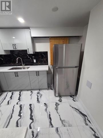 Whitby (Pringle Creek) duplex for rent - A modern kitchen with a marble floor and a stainless steel refrigerator.