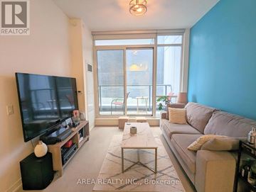 Toronto (Waterfront Communities) condo for rent - A living room with a flat screen TV and a glass door leading to a balcony.