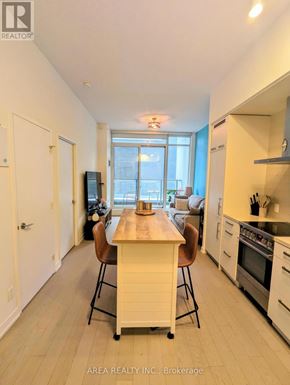 Toronto (Waterfront Communities) condo for rent - A kitchen with a table and chairs in the middle of the room.