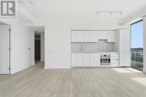 Toronto (Thorncliffe Park) condo for rent - A white kitchen with a refrigerator, cabinets, and a stove top oven.