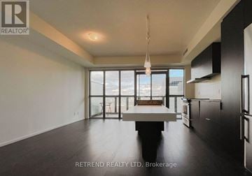Toronto (Church-Yonge Corridor) condo for rent - A spacious kitchen with a dining table and chairs, and a large window overlooking the city.