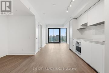 Toronto (Thorncliffe Park) condo for rent - A spacious kitchen with white cabinets and a view of the city through the window.