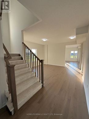 Loyalist (Bath) apartment for rent - A hallway with wooden floors and a staircase with a wooden railing.