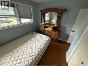 Windsor apartment for rent - A bedroom with a bed, vanity, and a window.