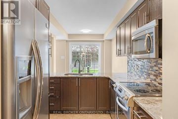 Ottawa townhouse for rent - A kitchen with a stainless steel refrigerator and wooden cabinets.