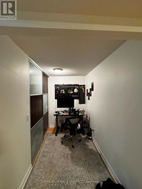 Mississauga (City Centre) condo for rent - A long hallway with a desk and chairs at the end.