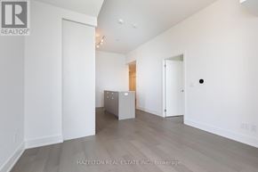Toronto (Yonge-Eglinton) condo for rent - A spacious room with a cabinet in the middle and a door on the right.