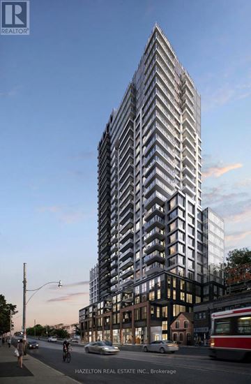 Toronto (East End-Danforth) condo for rent - A tall building with many windows is being constructed on a city street.