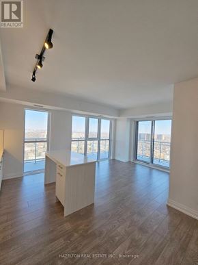 Toronto (East End-Danforth) condo for rent - A well-lit, empty room with a large window and a wooden floor.