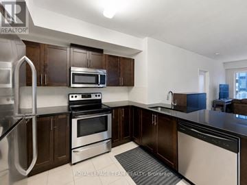 Ottawa condo for rent - A kitchen with stainless steel appliances and wooden cabinets.