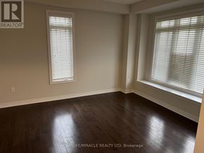 Collingwood apartment for rent - A room with wooden floors and two windows with blinds.