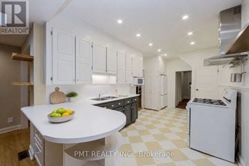 Toronto (The Beaches) apartment for rent - A modern kitchen with white cabinets and a checkered floor.