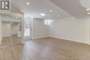 Whitchurch-Stouffville (Stouffville) apartment for rent - A spacious room with wooden flooring and a glass door leading outside.