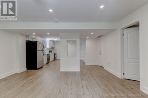 Whitchurch-Stouffville (Stouffville) apartment for rent - A spacious, empty room with wooden flooring and white walls.
