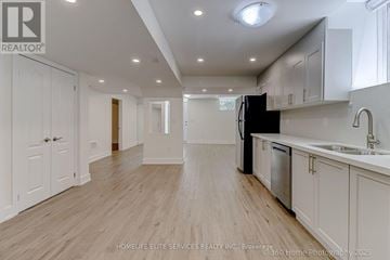 Whitchurch-Stouffville (Stouffville) apartment for rent - A spacious kitchen with white cabinets and a black fridge.