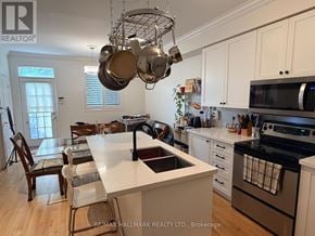 Toronto (East End-Danforth) apartment for rent - A kitchen with white cabinets and a large island with a sink.
