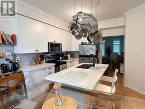 Toronto (East End-Danforth) apartment for rent - A kitchen with a white countertop and a hanging pot rack.