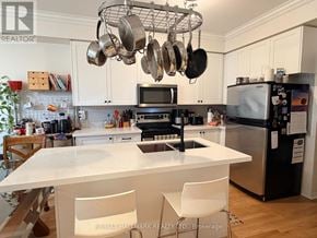 Toronto (East End-Danforth) apartment for rent - A kitchen with a white countertop and a black refrigerator.