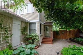 Milton (Tm Timberlea) apartment for rent - A house with a white door and a window is surrounded by green plants.