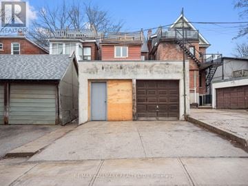 Toronto (High Park North) apartment for rent - A building with a grey garage door and a brown door is for sale.
