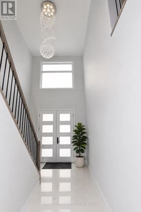 London North (North S) apartment for rent - A white hallway with a plant and a chandelier.