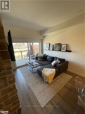 Blue Mountains condo for rent - A living room with a brick fireplace and a grey couch.