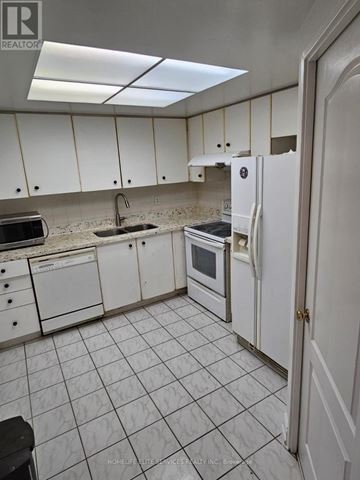 Toronto (Kennedy Park) condo for rent - A kitchen with white cabinets and appliances.