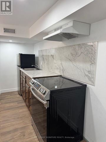 Toronto (Rouge) apartment for rent - A kitchen with a black oven and a marble backsplash.