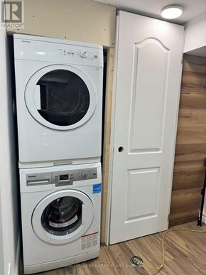 Toronto (Rouge) apartment for rent - A white dryer and washer in a small laundry room.