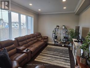 Thorold (Hurricane/Merrittville) apartment for rent - A living room with a brown leather couch and a striped rug.
