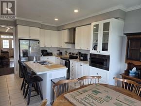 Thorold (Hurricane/Merrittville) apartment for rent - A kitchen with white cabinets and black chairs.