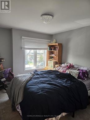 Thorold (Hurricane/Merrittville) apartment for rent - A bedroom with a large bed and a window with blinds.