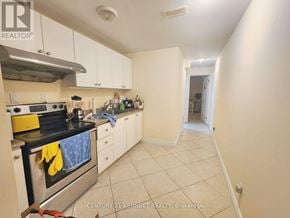 Toronto (Newtonbrook East) apartment for rent - A kitchen with white cabinets and a black stove top.
