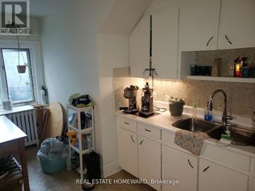 Toronto (High Park-Swansea) multi-family for rent - A kitchen with white cabinets and a sink.