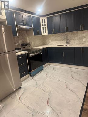 Brampton (Northwest Brampton) apartment for rent - A kitchen with a stainless steel refrigerator and black cabinets.