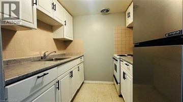 Kitchener townhouse for rent - A kitchen with white cabinets and a black fridge.