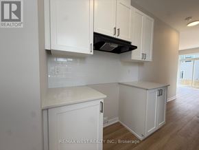 Ottawa townhouse for rent - A kitchen with white cabinets and a black stove top.
