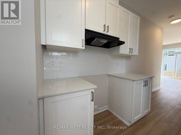 Ottawa townhouse for rent - A kitchen with white cabinets and a black stove top.