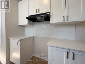 Ottawa townhouse for rent - A kitchen with white cabinets and a black range hood.